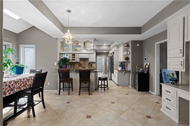 132 The Woodlands Dr, Gladstone, MO 64119 - dining room featuring baseboards, a chandelier, and light tile patterned flooring