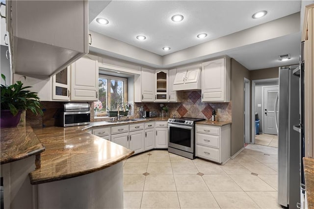 132 The Woodlands Dr, Gladstone, MO 64119 - kitchen featuring stainless steel appliances, a peninsula, a sink, custom exhaust hood, and backsplash