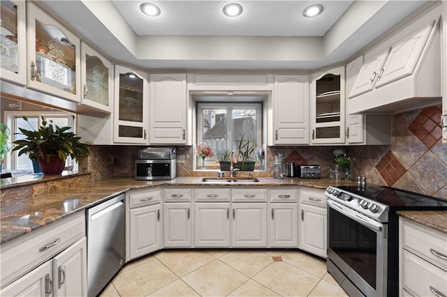 132 The Woodlands Dr, Gladstone, MO 64119 - kitchen featuring white cabinets, dark stone counters, stainless steel appliances, and a sink