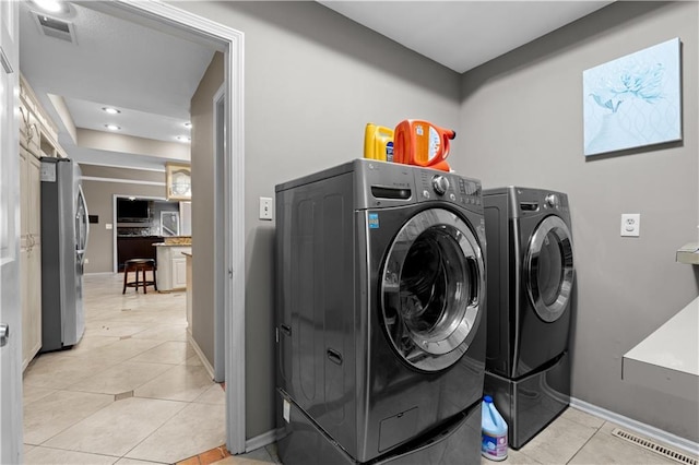 132 The Woodlands Dr, Gladstone, MO 64119 - laundry area with visible vents, washer and clothes dryer, laundry area, and light tile patterned floors