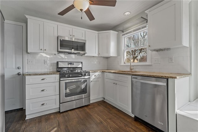 kitchen featuring a sink, dark wood finished floors, appliances with stainless steel finishes, white cabinets, and ceiling fan