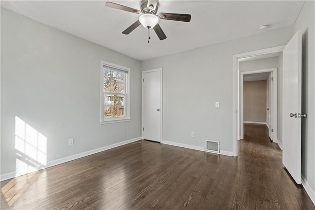 unfurnished bedroom featuring visible vents, baseboards, ceiling fan, and dark wood-style flooring