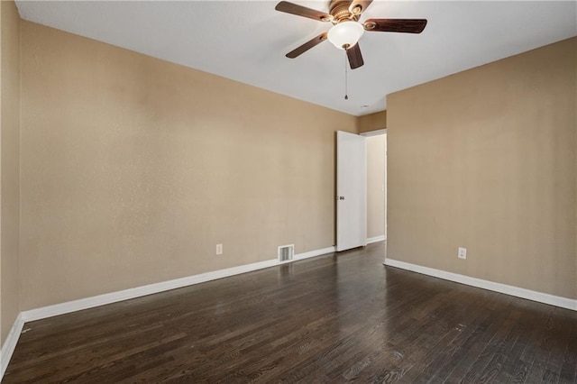 spare room with a ceiling fan, visible vents, baseboards, and dark wood-style flooring