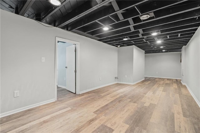 finished below grade area featuring light wood-type flooring and baseboards