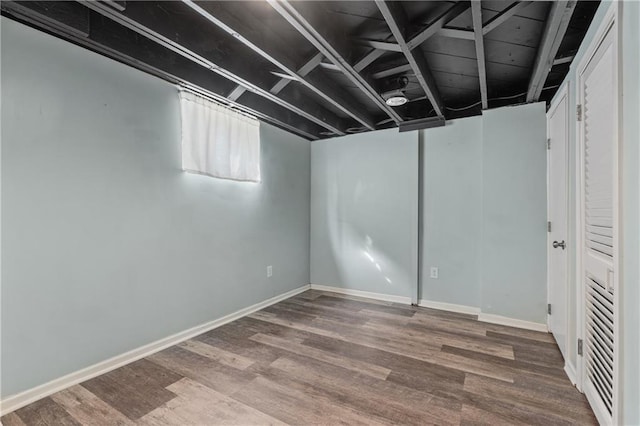 below grade area featuring wood finished floors and baseboards