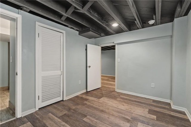 finished below grade area featuring baseboards and wood finished floors