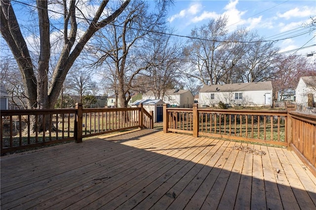 wooden deck with an outbuilding, a shed, and a residential view