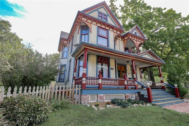 victorian house with a porch and fence