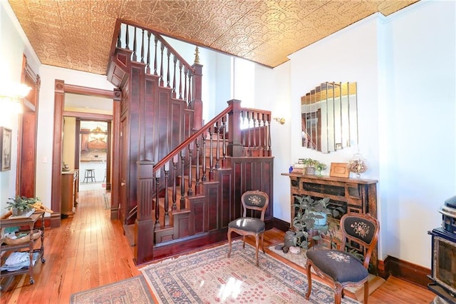 staircase featuring hardwood / wood-style flooring, an ornate ceiling, and baseboards