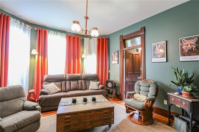 living area featuring a notable chandelier, baseboards, and wood finished floors