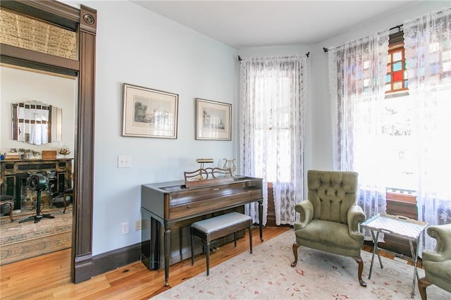 living area with baseboards and wood finished floors