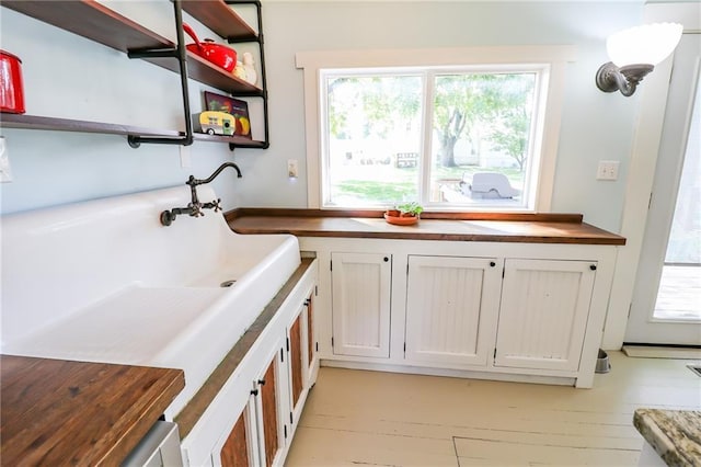 interior space featuring butcher block countertops, white cabinetry, and open shelves