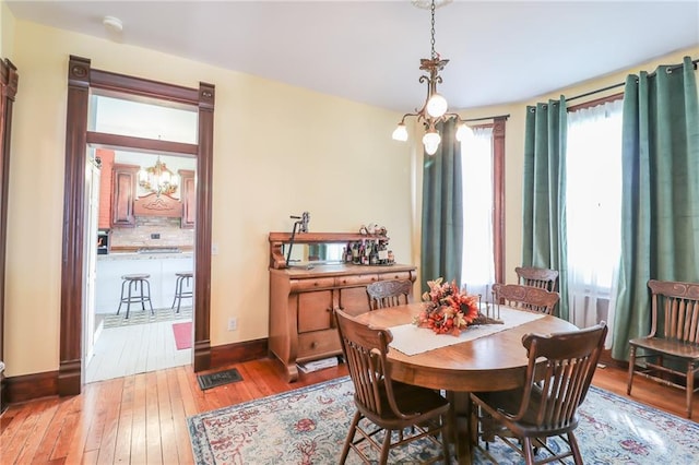 dining space with light wood-style flooring and baseboards