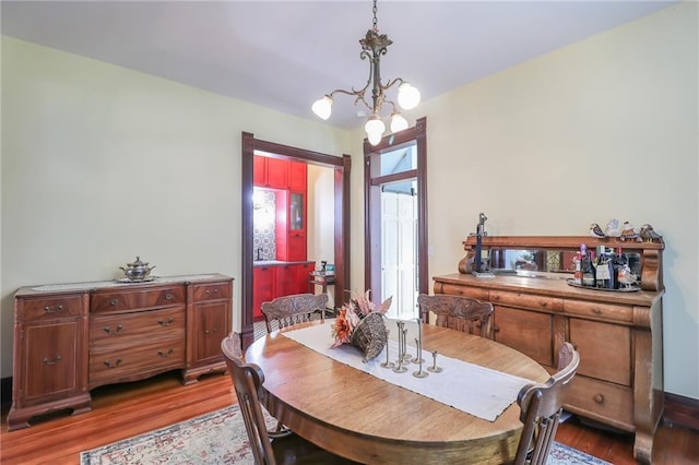 dining space featuring a notable chandelier and wood finished floors