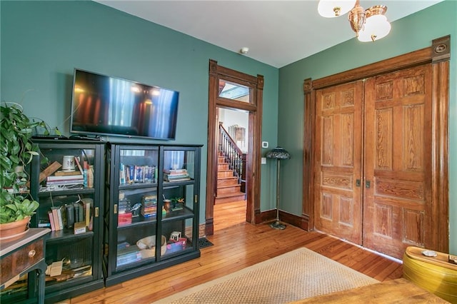 entryway featuring hardwood / wood-style flooring, baseboards, and stairway