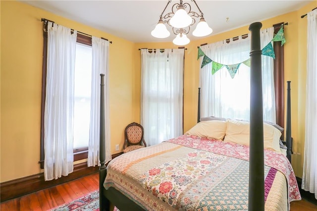 bedroom with an inviting chandelier and wood finished floors