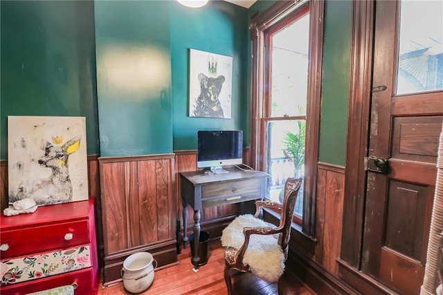 office space with wainscoting, wood finished floors, and a healthy amount of sunlight