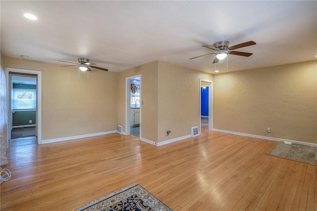 unfurnished living room featuring baseboards, visible vents, and light wood finished floors