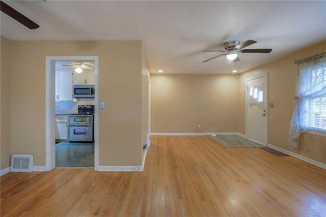 foyer featuring light wood finished floors, baseboards, visible vents, and ceiling fan