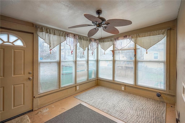 unfurnished sunroom with a ceiling fan