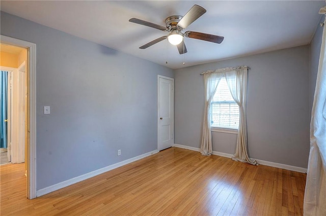 unfurnished room with light wood-style flooring, baseboards, and a ceiling fan