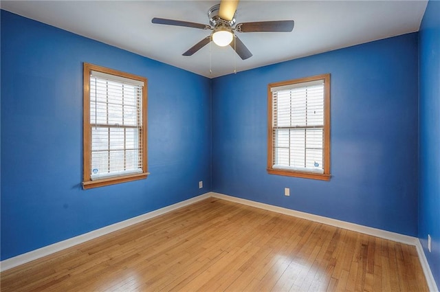 empty room with ceiling fan, wood-type flooring, and baseboards