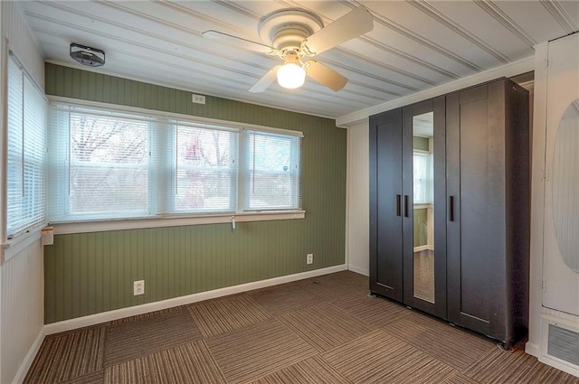 unfurnished bedroom featuring ceiling fan, baseboards, and carpet flooring