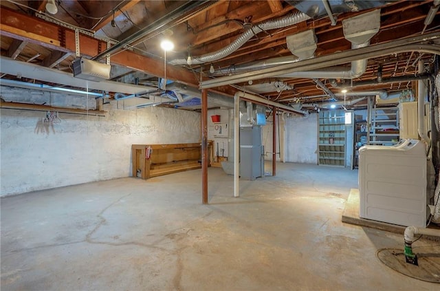 unfinished basement with heating unit and washer and clothes dryer