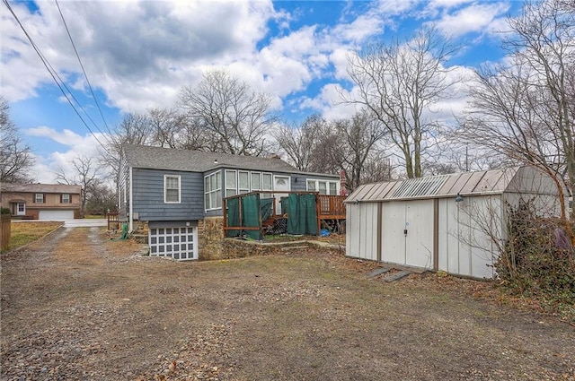 back of house with a storage unit and an outdoor structure