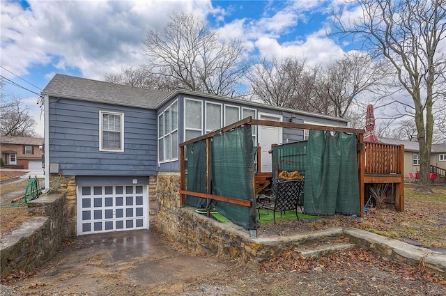 exterior space featuring a garage, stone siding, driveway, and roof with shingles