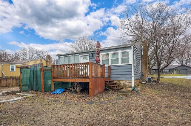 back of house featuring a deck, a chimney, fence, and central air condition unit