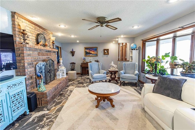 living area with a textured ceiling, a fireplace, and a ceiling fan