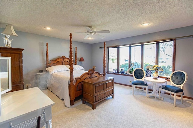 bedroom featuring baseboards, light carpet, a textured ceiling, and a ceiling fan