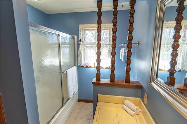 bathroom with tile patterned flooring, baseboards, and a shower with shower door