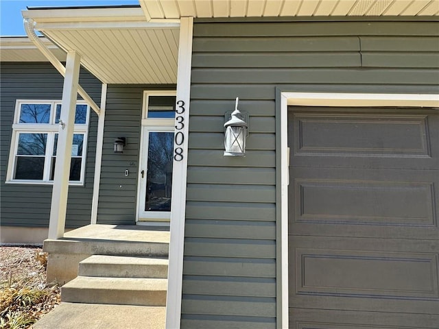 view of exterior entry featuring an attached garage