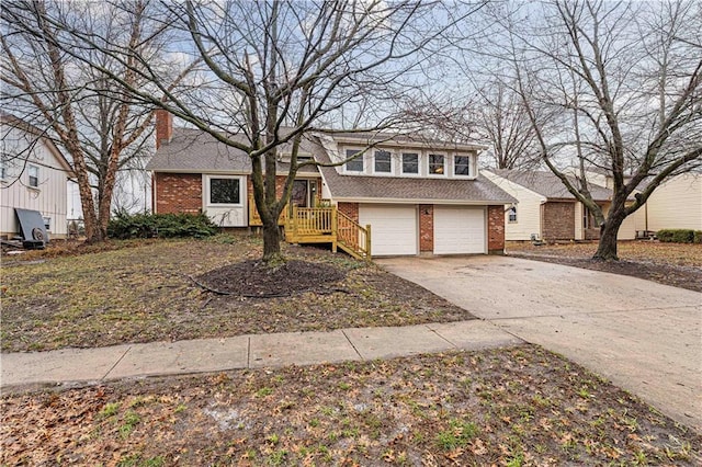 tri-level home featuring a garage, brick siding, a shingled roof, driveway, and a chimney