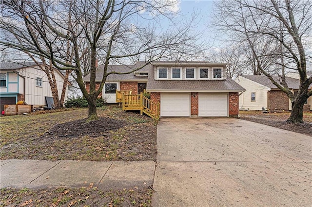 tri-level home with concrete driveway, brick siding, and an attached garage