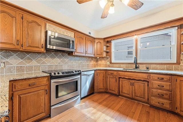 kitchen featuring stainless steel appliances, brown cabinets, and a sink