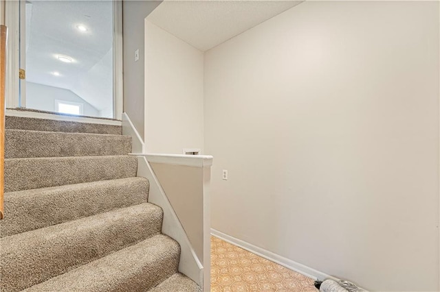 staircase with baseboards and vaulted ceiling