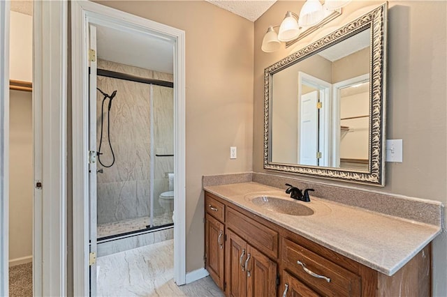 full bathroom featuring toilet, vanity, baseboards, a spacious closet, and a shower stall