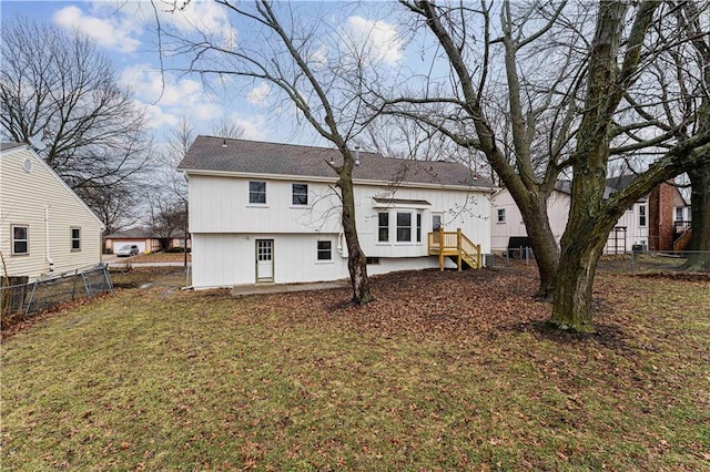 back of house featuring fence and a lawn