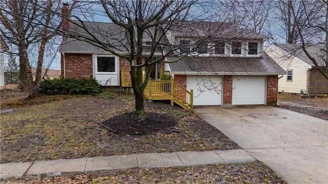 tri-level home with driveway, roof with shingles, and brick siding