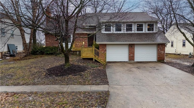 split level home featuring a shingled roof, concrete driveway, and brick siding