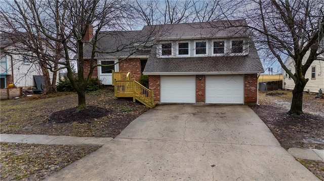 tri-level home featuring a shingled roof, concrete driveway, and brick siding