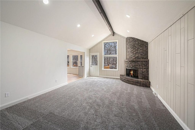 unfurnished living room featuring carpet floors, a fireplace, lofted ceiling with beams, and baseboards