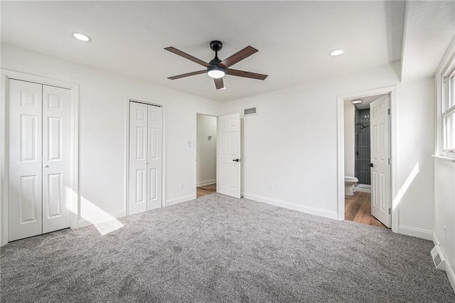 unfurnished bedroom featuring recessed lighting, carpet flooring, visible vents, baseboards, and two closets