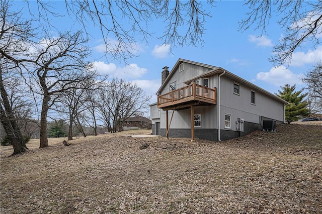 view of property exterior with a deck, a chimney, and central AC unit