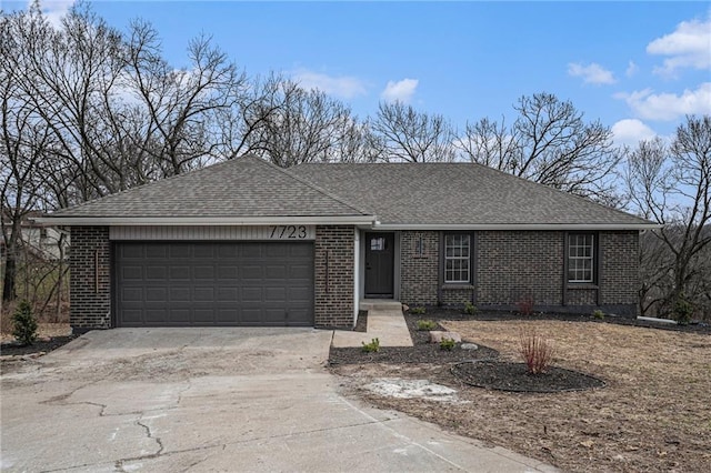 ranch-style house with an attached garage, a shingled roof, concrete driveway, and brick siding