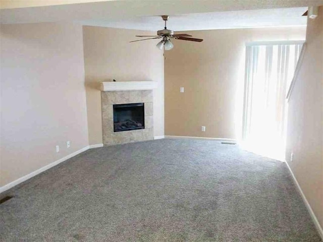 unfurnished living room with baseboards, carpet, ceiling fan, and a fireplace