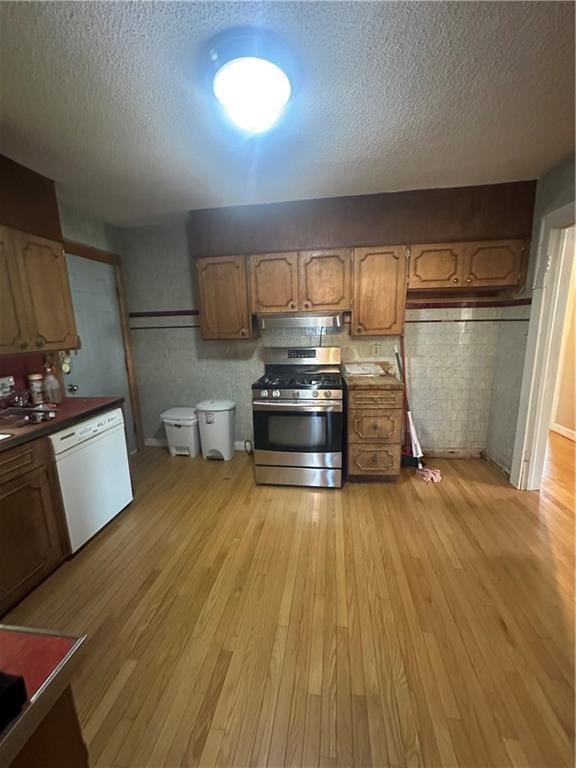 kitchen featuring light wood-type flooring, a textured ceiling, dishwasher, and gas stove